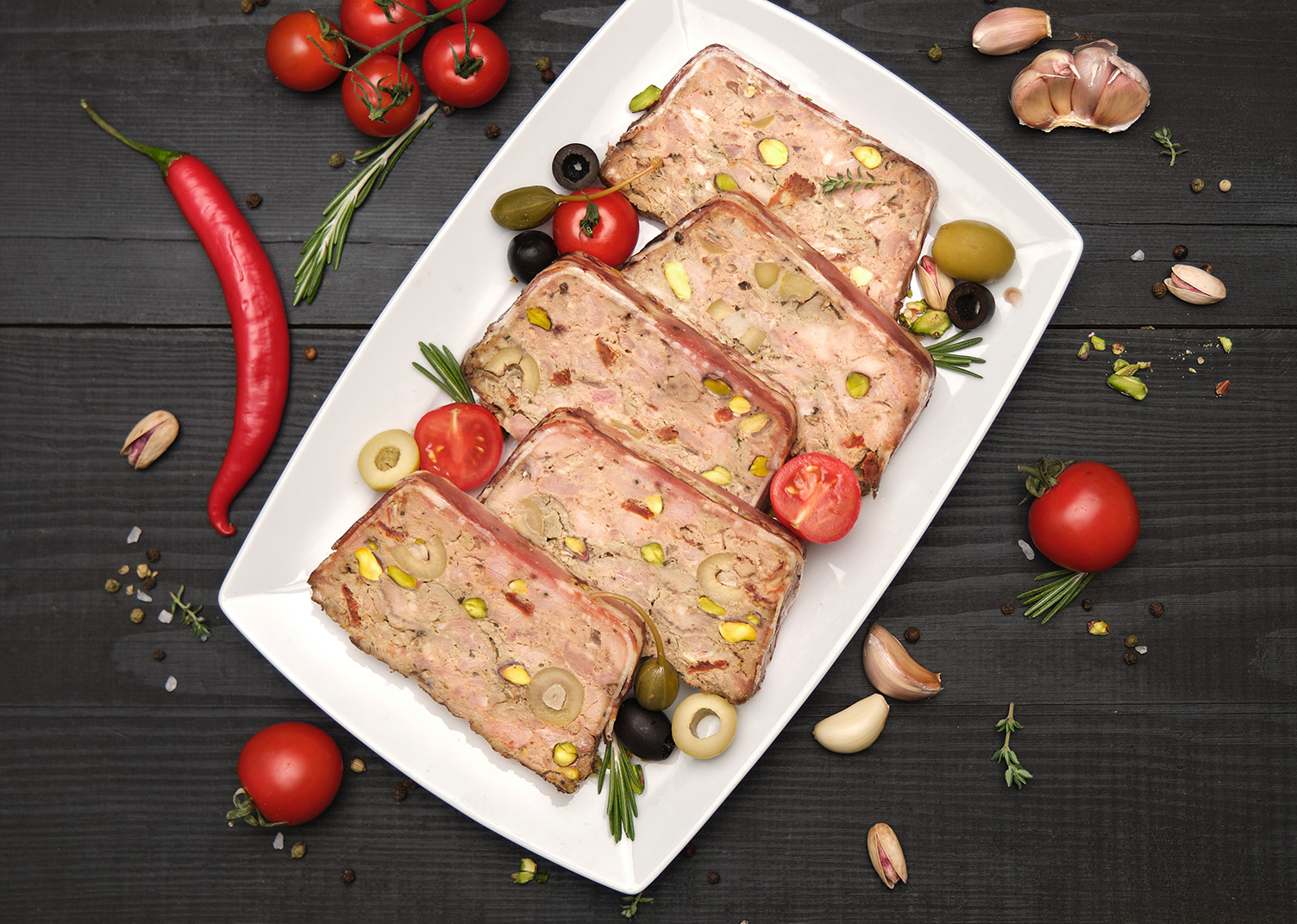 Sliced Traditional French terrine covered with bacon on dark wooden background. High quality photo