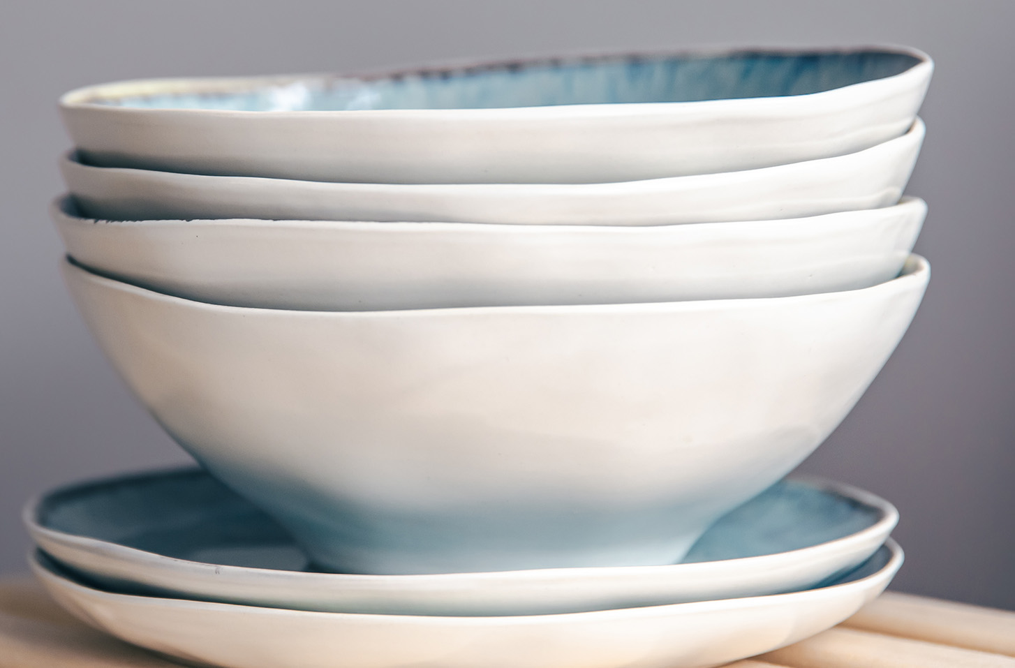 A set of beautiful plates in pastel colors on a gray background, copy space.
