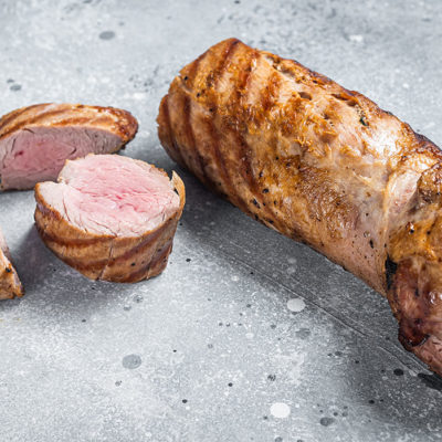 BBQ roasted pork tenderloin fillet meat. Gray background. Top view. Copy space.